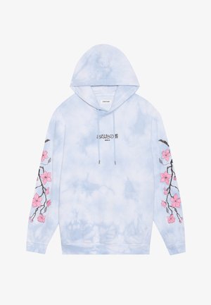 Svetlo modra kapuca s tie-dye vzorom, črno japonsko besedilo in "Berlin" na prsih, ter izvezeno rožo češnjevega cveta v roza barvi na obeh rokavih.