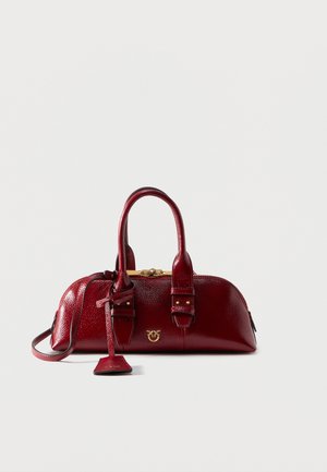 Kicsi, texturált sötétvörös bőrtáska két felső fogantyúval, arany kapoccsal és díszes arany logóval az elején.