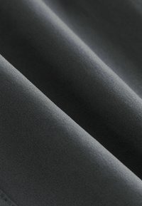 Donkergrijze stof met een gladde textuur, voorzien van een subtiele glans en nette plooien, die de lichte en flexibele eigenschappen benadrukken.