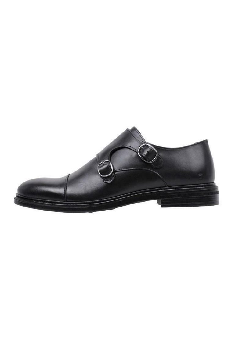 Zapato de vestido de cuero negro con dos hebillas decorativas, punta redondeada y un acabado suave. Presenta un tacón bajo y apilado, con un diseño minimalista.