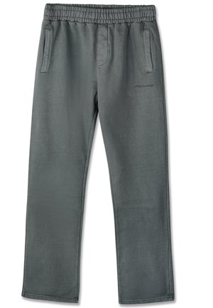 Homme portant un sweat à capuche noir zippé, mains dans les poches, pantalon gris et baskets blanches, debout sur un fond blanc uni.