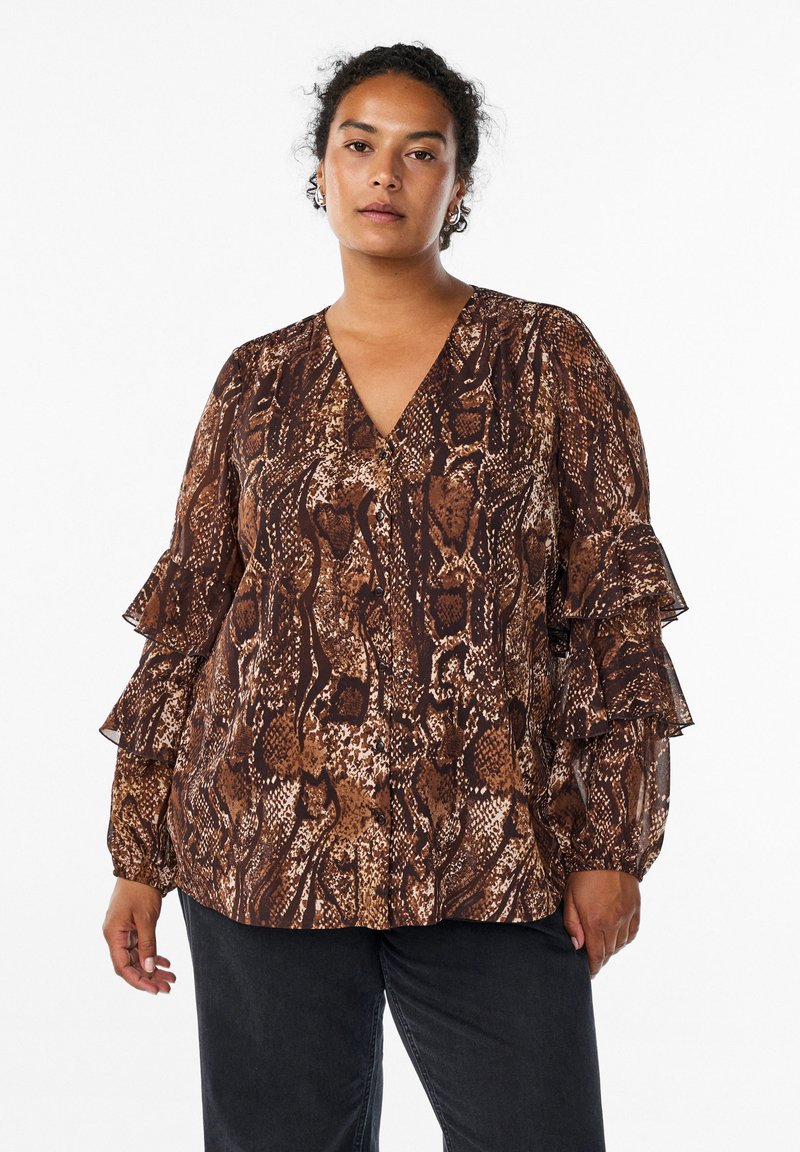 Brown snake print blouse with a V-neck, ruffled sleeves, and button details, made from a lightweight material. Paired with black pants.