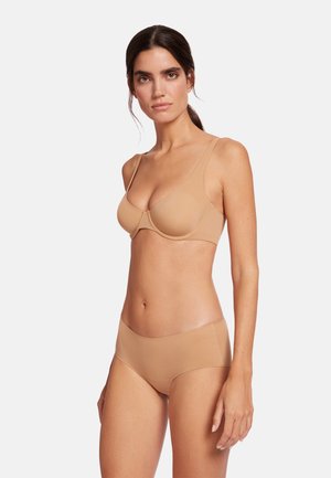 Naadloze nude bh met verstelbare banden en zachte cups, gecombineerd met bijpassende hoog-getailleerde slipjes, beide van glad, rekbaar materiaal.