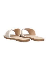 Sandalias tipo slide de punta abierta con parte superior de tela beige, suela de goma marrón y diseño plano. Presentan una textura suave y un estilo minimalista.