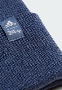 Beanie lavorato a maglia blu navy con un motivo testurizzato e etichette cucite con i loghi di Adidas e Disney. Materiale morbido e elasticizzato.