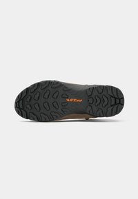 Zapato de exterior con una suela de goma negra texturizada y patrones de dibujo prominentes, mostrando un empeine marrón. Logotipo de la marca impreso en naranja.