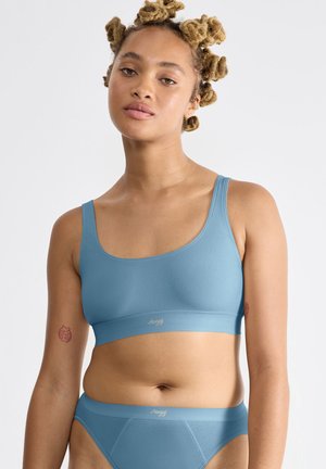 Lichtblauwe naadloze bralette en bijpassende slipset, gemaakt van een gladde stof. Kenmerkt zich door brede banden en een minimalistisch ontwerp met een subtiele logo.
