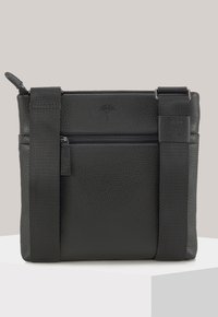 Černá kožená kabelka přes rameno s texturovaným povrchem, nastavitelným látkovým popruhem a předním zipem na kapsu. Na přední straně je logo jako detail.