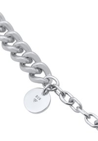 Bracelet en chaîne argentée avec de grands maillons entrelacés. Possède une petite plaque ronde gravée du motif "925" pour indiquer la qualité de l'argent sterling.