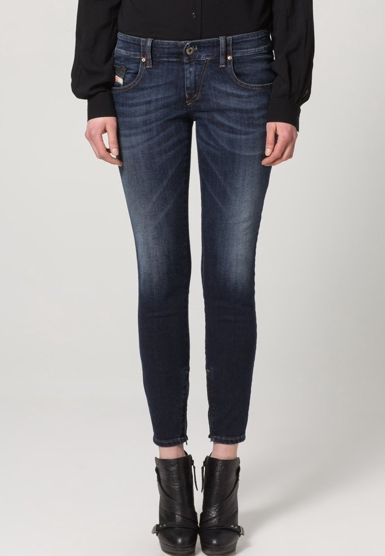 Smaljeans i mörk denim med medelhög midja, subtila blekningar, framfickor och en kroppsnära ankellång design.