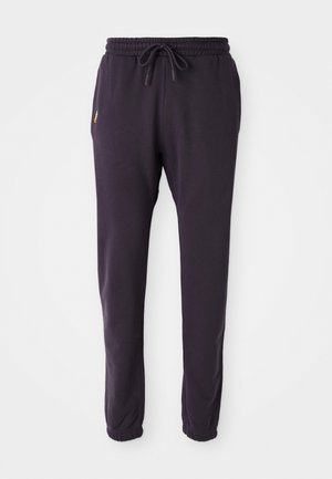Pantaloni della tuta viola con vita elastica e cordoncino, dotati di elastici alle caviglie e un piccolo logo sul lato.
