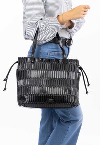 Zwarte glanzende tote bag met gestructureerde verticale plooien. Voorzien van twee schouderbanden en trekkoordaccenten aan de zijkanten.