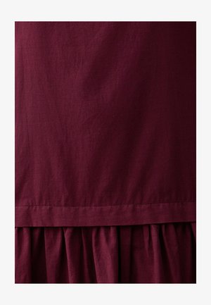 Bordeaux jurk met een gladde, lichte textuur, met een verzamelde, gerimpelde zoom en een eenvoudig, ongecompliceerd ontwerp.