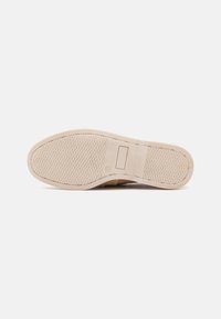 Beige színű sneaker talp, texturált gumiból készült, gyémántmintával és sima téglalap alakú díszítéssel a saroknál. Könnyű és rugalmas kialakítás.