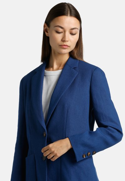 Blue linen blazer with notched collar, two front pockets, and button closure. Features brown buttons on sleeves and a relaxed fit.