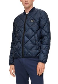 Marineblau gesteppte Bomberjacke mit einem schwarzen Reißverschluss, geripptem Kragen und seitlichen Taschen, mit einem Logopatch auf der linken Brust.