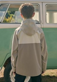 Leichte, kapuzenjacke im beige und grau Farbkombination, mit lockerer Passform und glatter Textur, mit schlichter Rückansicht.