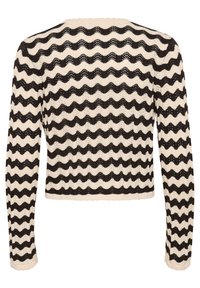 Pull en tricot à manches longues, présentant un motif ondulé noir et crème. Tissu texturé et détail de ourlet festonné.