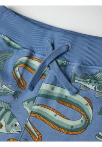 Blauwe shorts met een vispatroon in groen en oranje, voorzien van een geribde band en koord, gemaakt van een zachte stof.