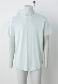 Šviesiai mėlynas trumpomis rankovėmis marškinėliai iš minkštos medžiagos. Turi apvalią kaklo iškirptę ir tiesų apatinį kraštą, pavaizduoti ant manekeno.