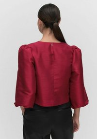 Bordeaux satin top med pufærmer og rund halsudskæring, med en lille knaplukning bagpå og et cropped design.