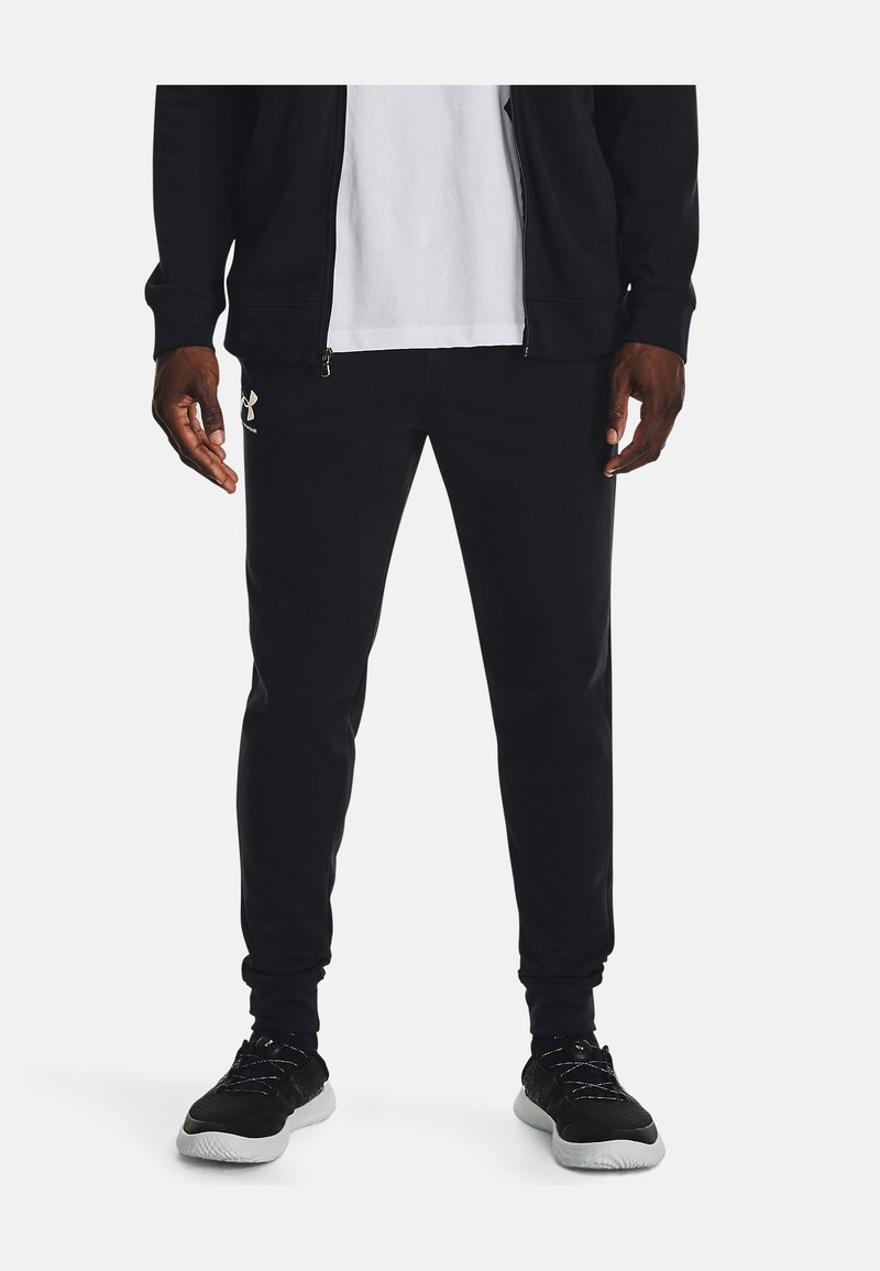Mustad mustad püksid, mis on pehme ja slim-fit lõikega, realt paelaga vöö, küljetaskud ja diskreetne logo vasakul reitel. Pehme kangastekstuuri.