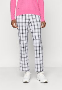 Valged ja mustad ruudulised püksid sirge lõikega, koos roosa ribakudumisega sallist ja valgete tennisetossudega. Sile kangakvaliteet.