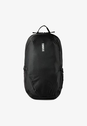 Zwarte Thule rugzak met bovenhandvat, gevoerde voorkant, ritsen en verticale witte logo gecentreerd op het voorpaneel.