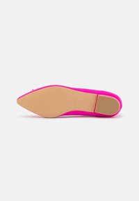 Zapato de tacón alto fucsia con una textura suave, punta afilada y una suela beige sólida que presenta patrones de tracción lineales.