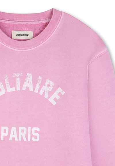 Różowa bluza z okrągłym dekoltem z białym, postarzanym napisem "BLAIRE" i "PARIS", z metką Zadig & Voltaire wewnątrz kołnierza.