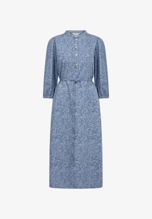 Vaaleansininen keskipituinen mekko, jossa on kukkakuosi, nappisulku, mandariinikaulus ja nyöritetty vyötärö. Varustettu pitkillä, rypytetyillä hihoilla.