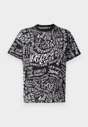 T-shirt en coton noir présentant un design chaotique avec du texte blanc, incluant "Versace" et "Jeans Couture", dans des tailles et orientations variées.