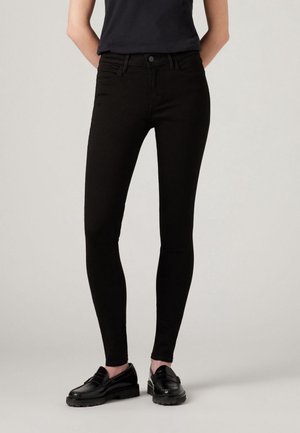 Jean skinny noir avec un design classique à cinq poches, en denim extensible, avec une texture lisse et une taille mi-haute.