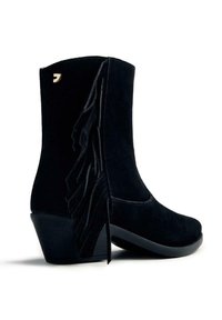 Botas de tobillo de ante negro con punta cuadrada, que presentan detalles de flecos verticales a lo largo del costado y un tacón bajo y estructurado.