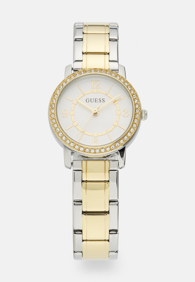 Relógio redondo em aço inoxidável com uma bracelete em metal com links prateados e dourados. O mostrador branco apresenta detalhes dourados e um bisel cravejado de cristais.