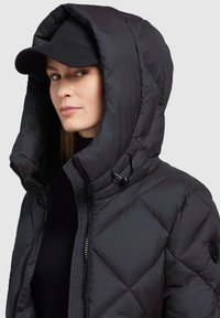 Black quilted puffer jacket with a large hood and a front zipper. Includes a drawstring feature and a black cap. Smooth, shiny texture.