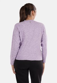 Maglione a maglia lilla con una finitura leggermente testurizzata, collo rotondo e orlo a coste. Presenta un piccolo logo stampato sul retro.
