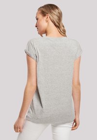 Grå kortærmet T-shirt med rullede manchetter, blødt stof, afslappet pasform og rundet søm, set fra ryggen.