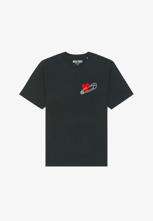 Melns kokvilnas T-krekls ar grafiku, kurā attēlots drošības adata un sarkans sirds simbols kreisajā pusē. Īsas piedurknes un apaļš kakla izgriezums.