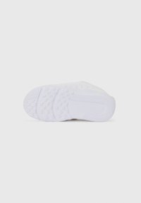 White athletic shoe sole featuring a textured pattern with grooves and grips for traction. Smooth, lightweight material with subtle branding.