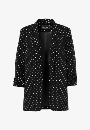 Mustvalge bleiser, millel on valged täpid, наклонной лацкан, ühe nupuga kinnitamine, rullitud varrukad, kerge kangas, sujuv tekstuur ja voodrita sisemus.