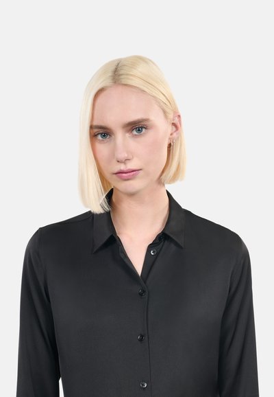 Camicia nera in satin con colletto, maniche lunghe e un leggero lucido; presenta bottoni neri e una superficie liscia.