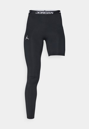 Shorts in tessuto compressivo neri con design aderente, caratterizzati da un logo sulla coscia sinistra e una cintura bianca con la scritta "JORDAN".