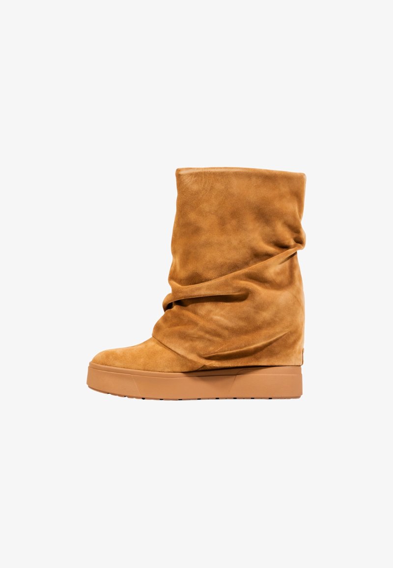 Stivale alla caviglia in suede beige con design morbido, tacco a zeppa e texture liscia. Presenta una punta arrotondata e suola in gomma minimale per una migliore aderenza.