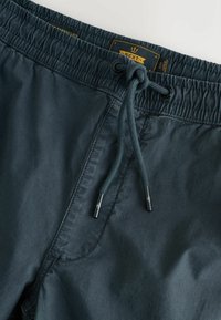 Marine Badehosen mit elastischem Bund und Kordelzug, aus leichtem Stoff gefertigt. Mit schwarzen Metallenden am Kordelzug.