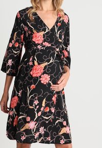 Blumenkleid in Schwarz, mit rosa und roten Blumenmustern, V-Ausschnitt und Dreiviertelärmeln sowie einer gefütterten Taille.