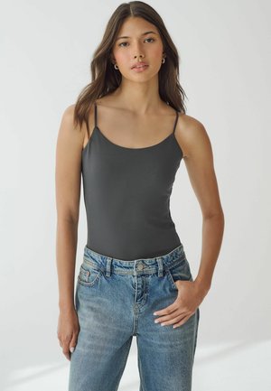 Body negru închis cu bretele subțiri ajustabile, asortat cu blugi deschiși la culoare, cu talie înaltă. Material neted și design ajustat.