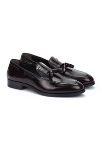 Mocasines de cuero marrón con un diseño elegante, que presentan un acento decorativo de lazo, puntera redondeada y costuras en contraste a lo largo de los bordes.