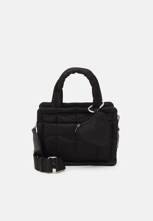 Sac à main noir matelassé avec des poignées rembourrées, une bandoulière réglable et une pochette zippée en forme de cœur attachée sur le devant.