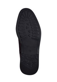 Semelle en caoutchouc noir avec un motif texturé pour une meilleure adhérence, avec une partie supérieure marron visible sur le bord. Comprend le logo "Tamaris".